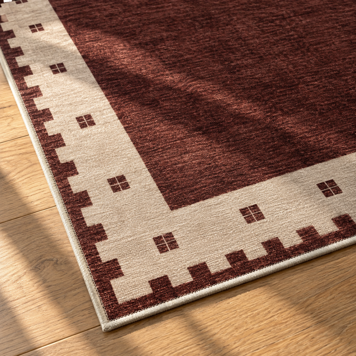 Apollo Evening Frame Area Rug — Burgundy / Cream — corner and edge detail in soft afternoon light. Digital visualization.