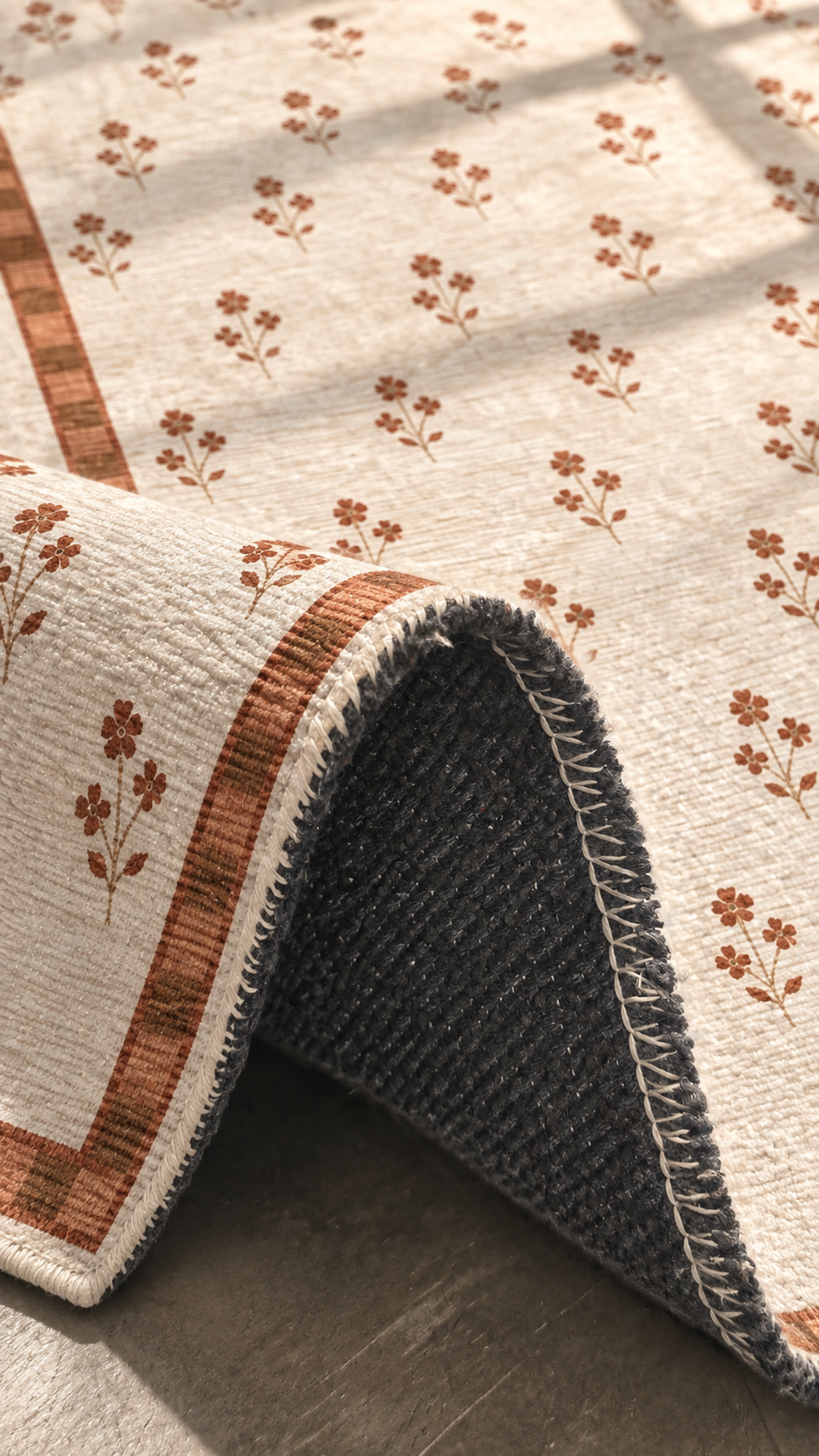 Apollo Posy Walk Area Rug — Terracotta / Beige — folded rug detail in soft afternoon light. Digital visualization.