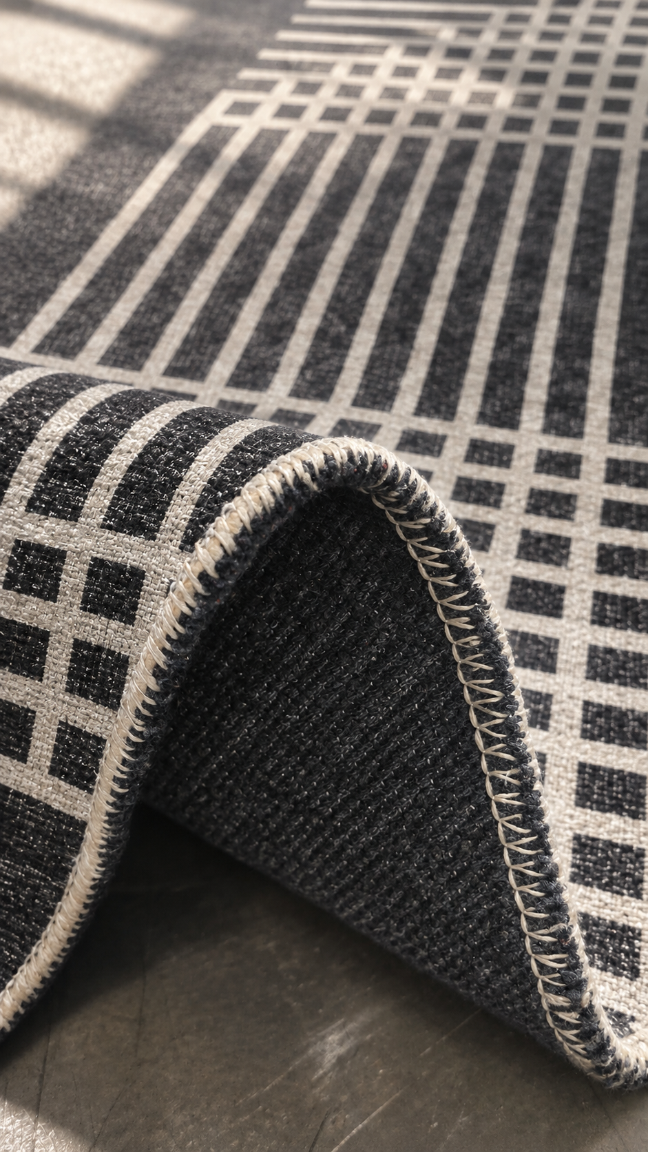 Apollo Crossline Study Area Rug — Charcoal / Cream — folded rug detail in soft afternoon light. Digital visualization.
