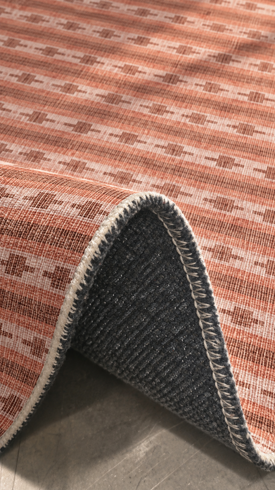 Apollo Keepsake Stripe Area Rug — Terracotta / Light Terracotta — folded rug detail in soft afternoon light. Digital visualization.