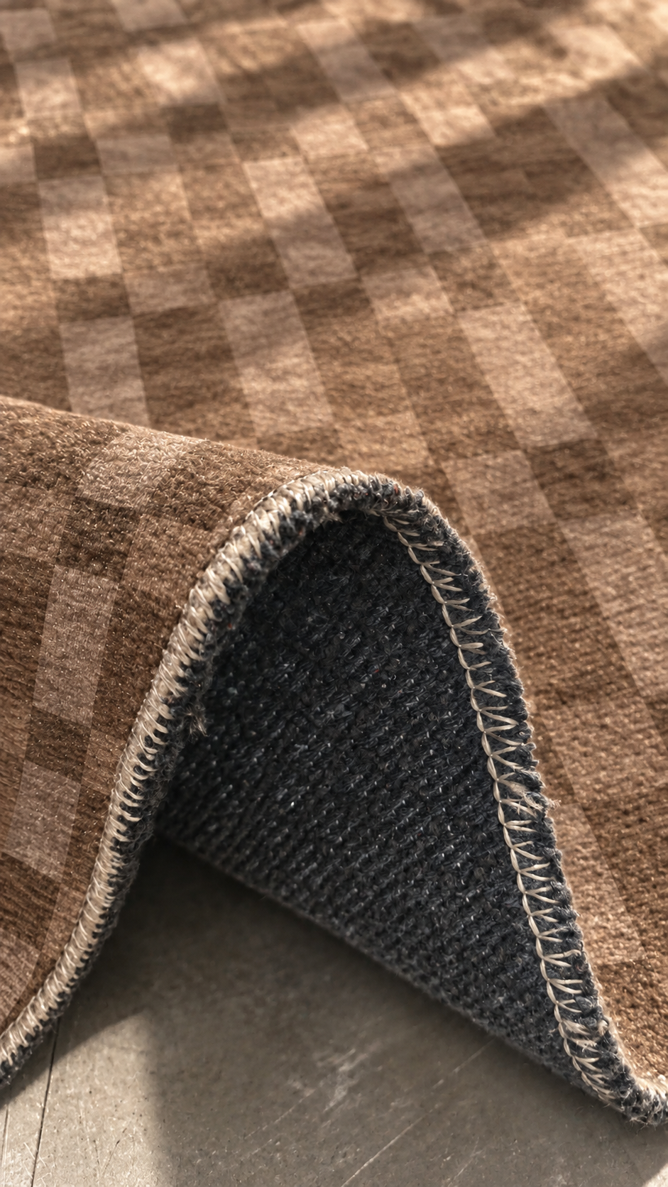 Apollo Pavilion Step Area Rug — Light Brown / Taupe — folded rug detail in soft afternoon light. Digital visualization.