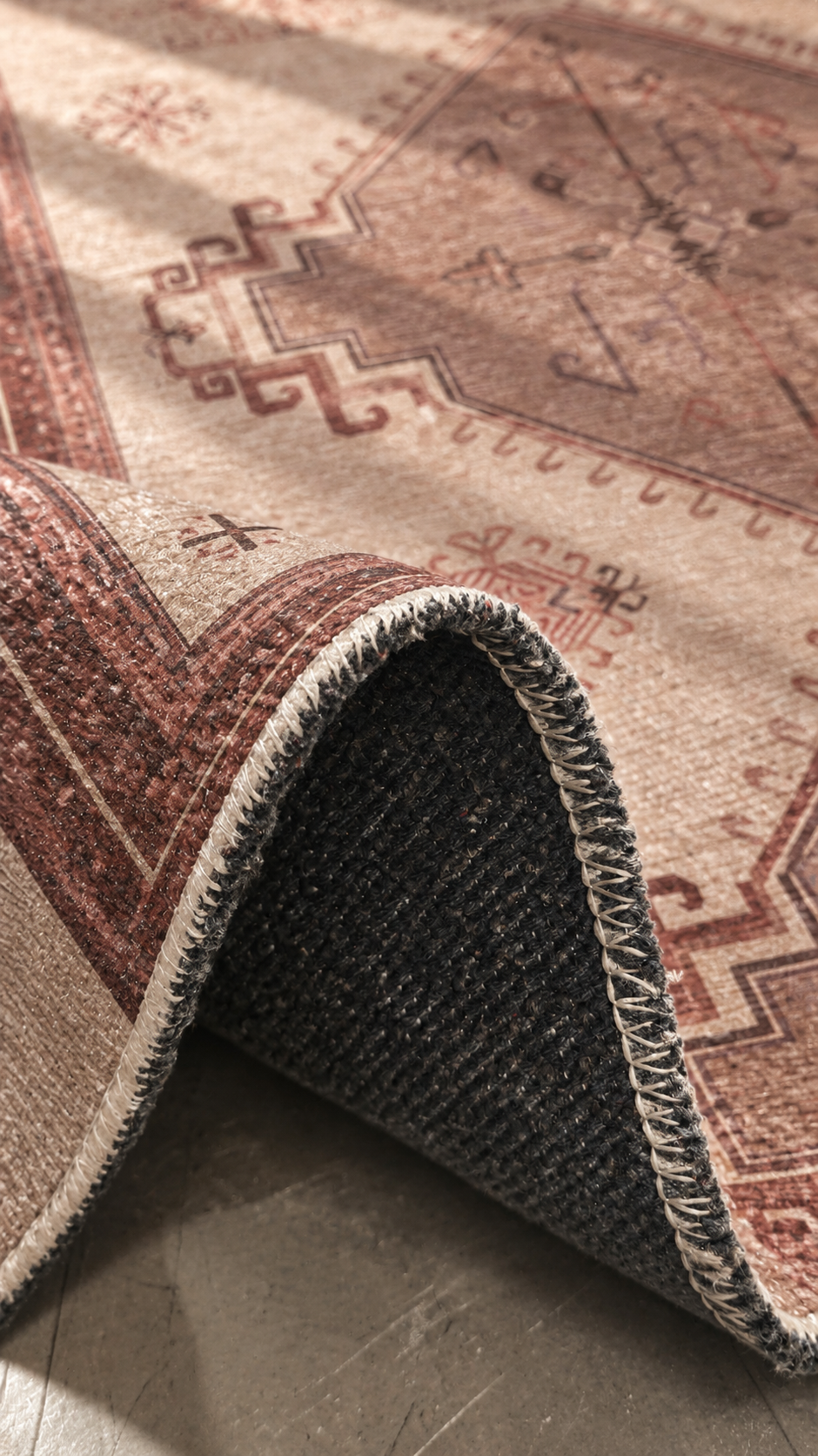 Apollo Wayfarer Court Area Rug — Dusty Burgundy / Beige — folded rug detail in soft afternoon light. Digital visualization.