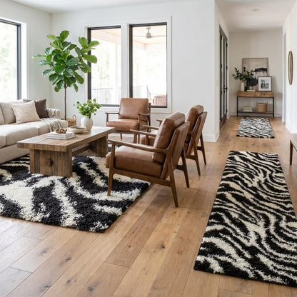7033 - Modern living room with brown leather chairs, a wooden coffee table, and  matching zebra print rugs (a zebra print area rug under the sofa and two zebra print runner rugs in the adjoining hallway)