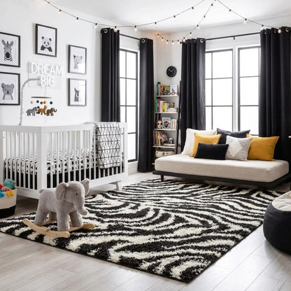 7033 - Nursery room with a black and white rug, white crib, and colorful pillows.