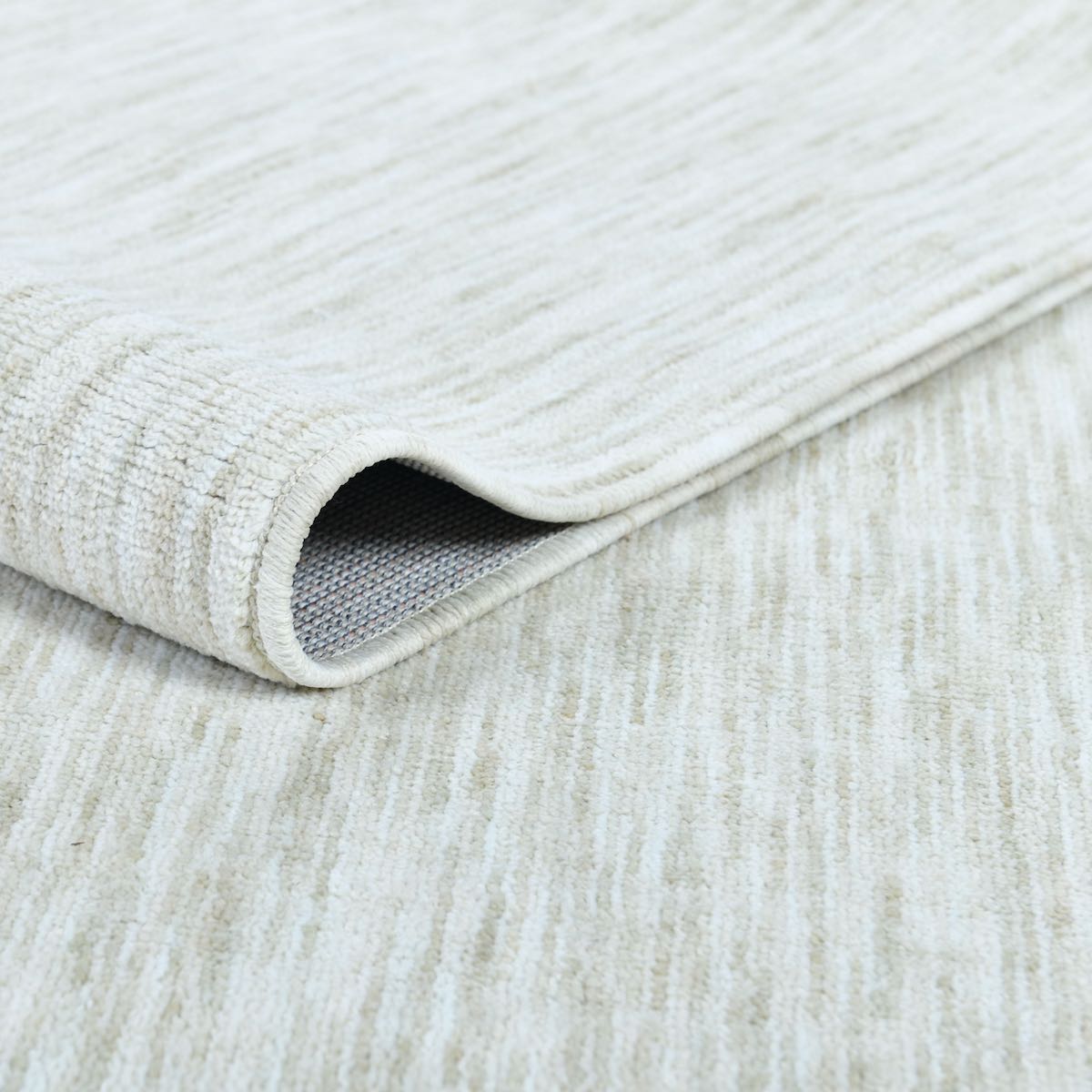 COD-12 Well Woven Moor Washable Rug: Close-up of a textured white and beige rug with a soft pile