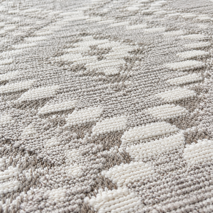 Close-up of a textured woven rug with a repeating geometric pattern in off-white and light gray.