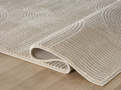 Lafayette Arc beige and cream curved lines area rug, rolled to show pile depth and the jute backing