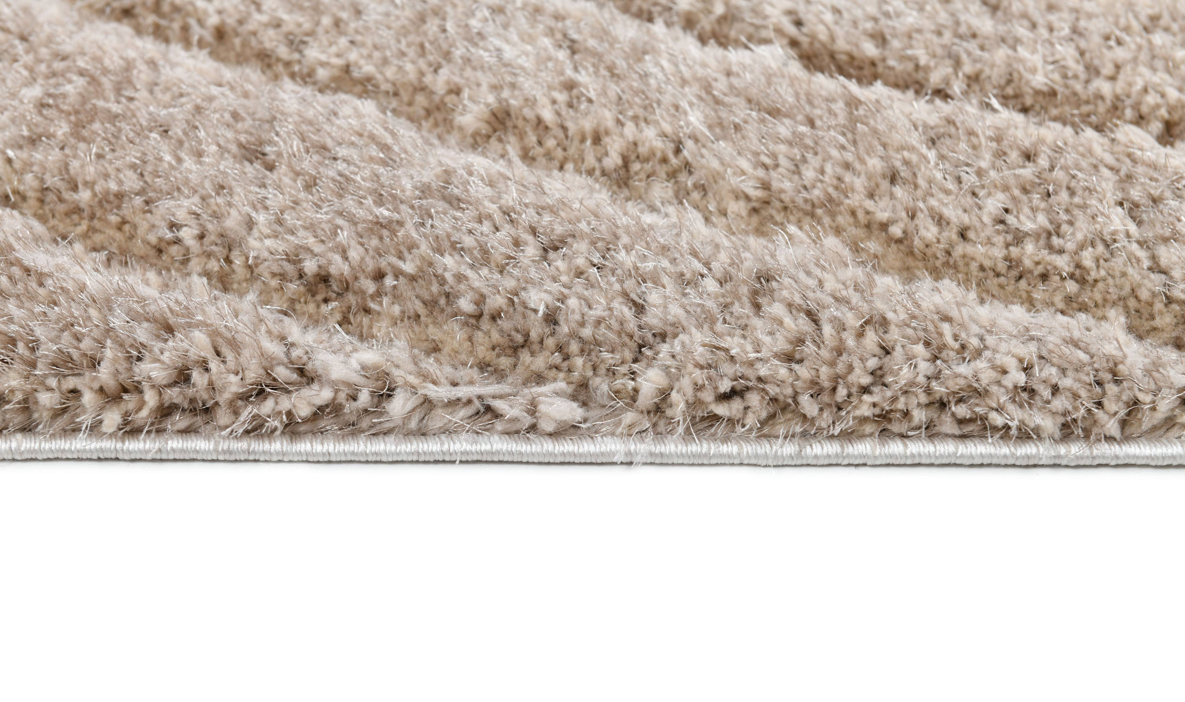 Side detail of the Ucci beige shag rug showing thick plush pile and bound edge