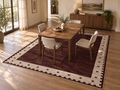 Apollo Evening Frame Area Rug — Burgundy / Cream — dining room in soft afternoon light. Digital visualization.