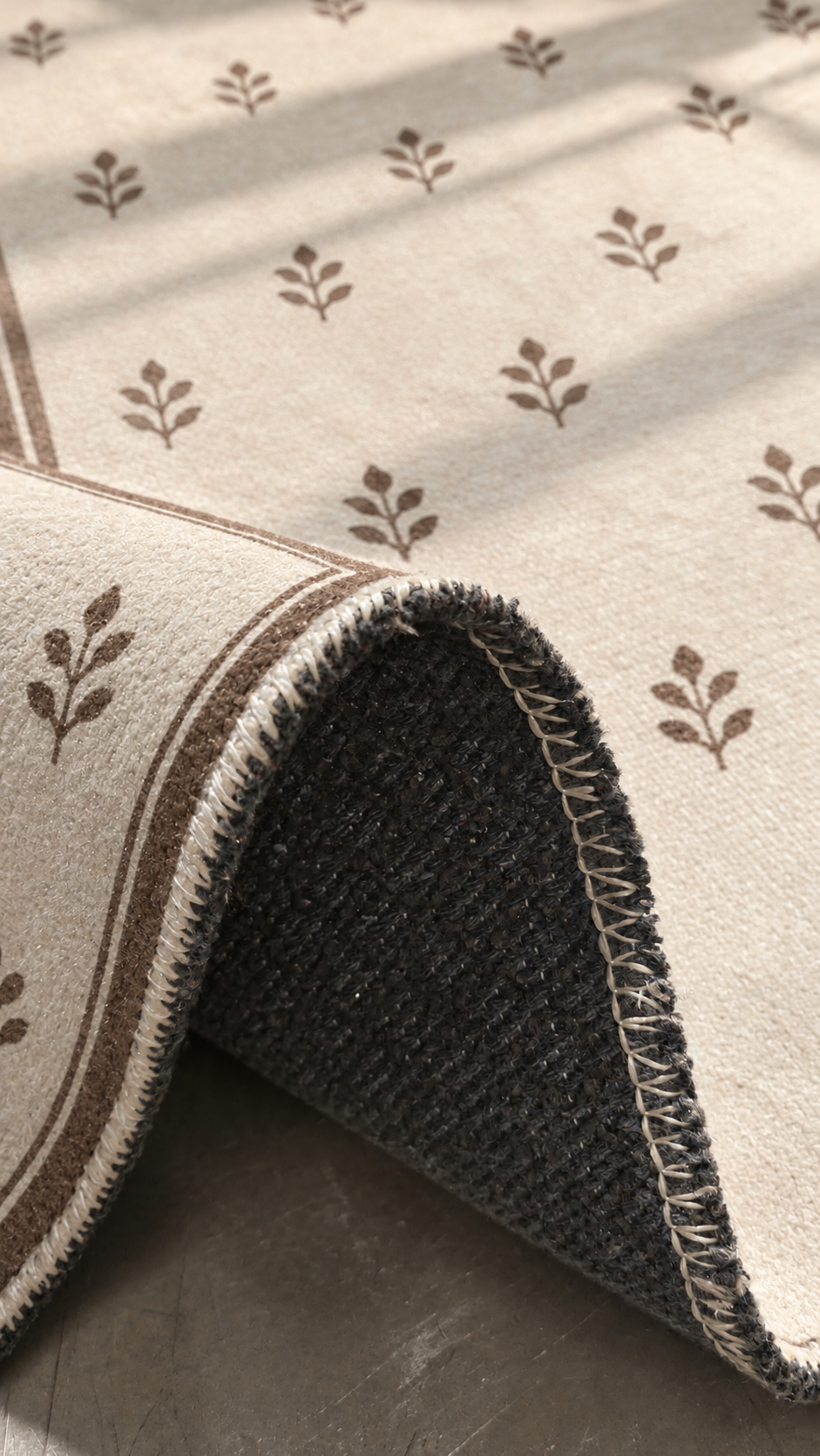 Apollo Little Orchard Area Rug — Brown / Cream — folded rug detail in soft afternoon light. Digital visualization.
