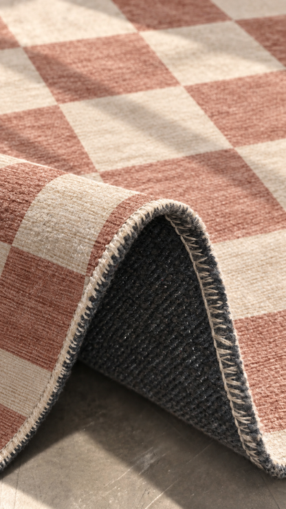 Apollo Sunday Check Area Rug — Dusty Rose / Cream — folded rug detail in soft afternoon light. Digital visualization.