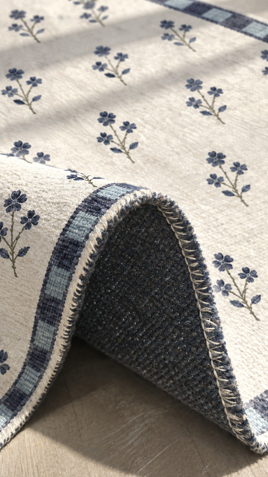 Apollo Posy Walk Area Rug — Navy / Cream — folded rug detail in soft afternoon light. Digital visualization.