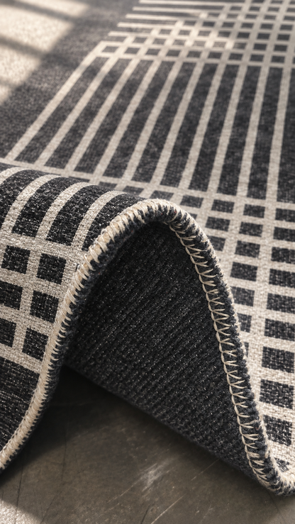 Apollo Crossline Study Area Rug — Charcoal / Cream — folded rug detail in soft afternoon light. Digital visualization.