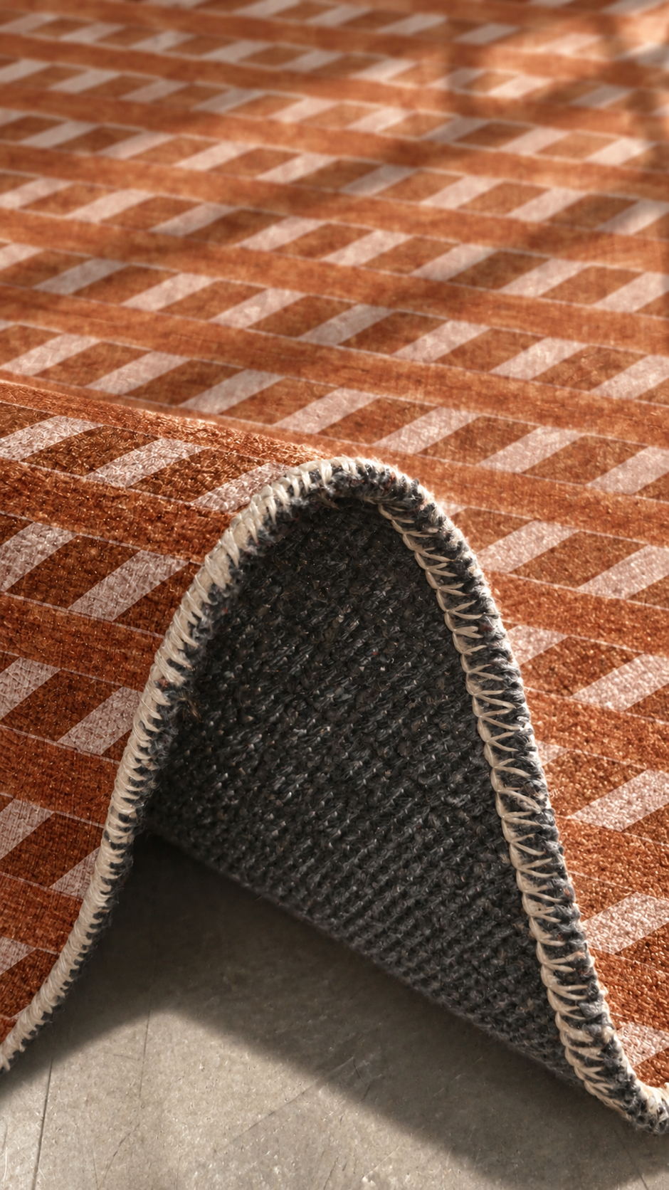 Apollo Slant Row Area Rug — Terracotta / Clay — folded rug detail in soft afternoon light. Digital visualization.