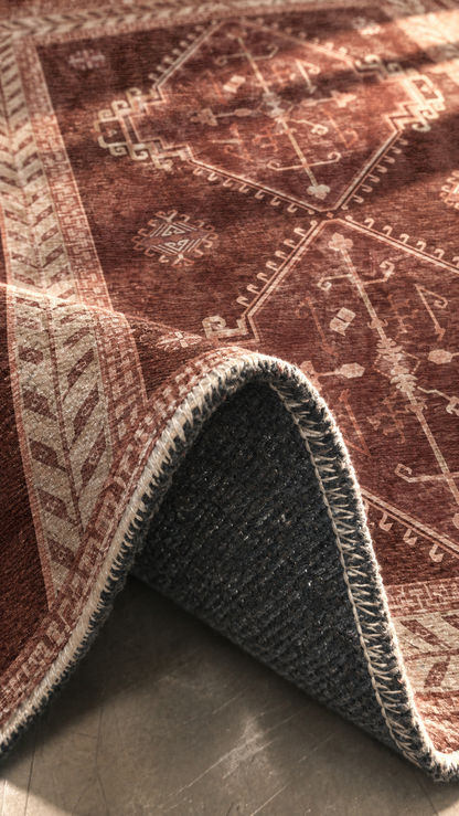 Apollo Wayfarer Court Area Rug — Deep Burgundy / Beige — folded rug detail in soft afternoon light. Digital visualization.