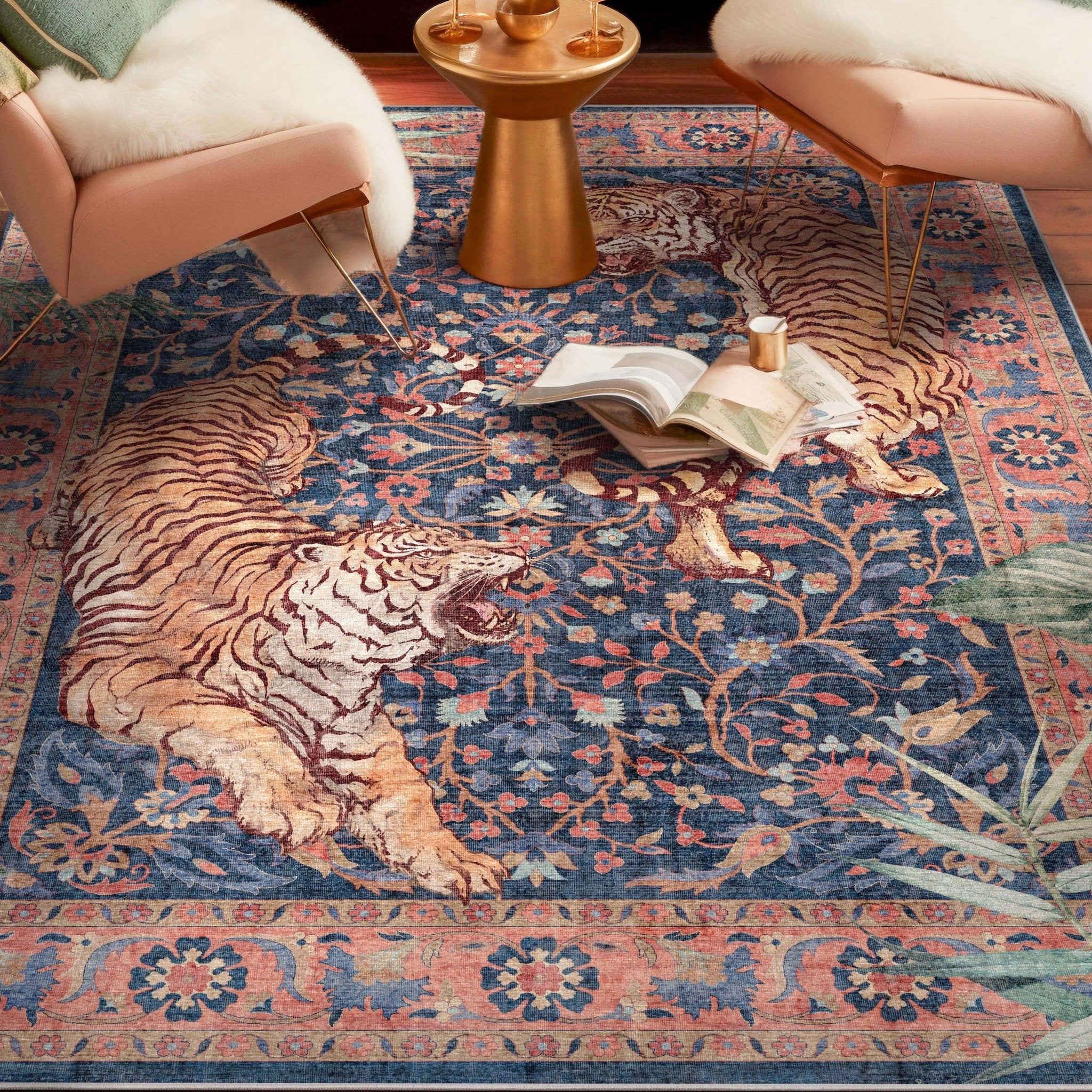 Tiger print navy low profile area rug under two blush accent chair and a gold accent table. Books are displayed open on the rug.