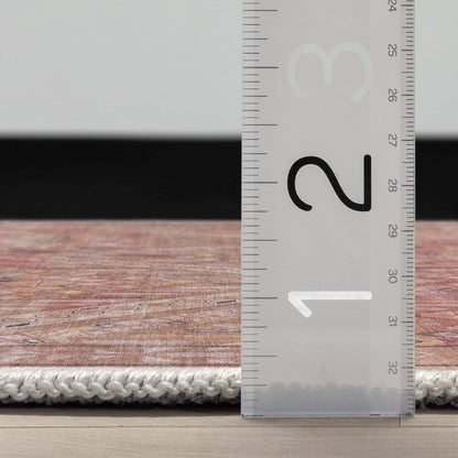 A side profile of the Asha Anya Flatwoven Custom Runner Rug with a ruler showing measurements on a wooden floor