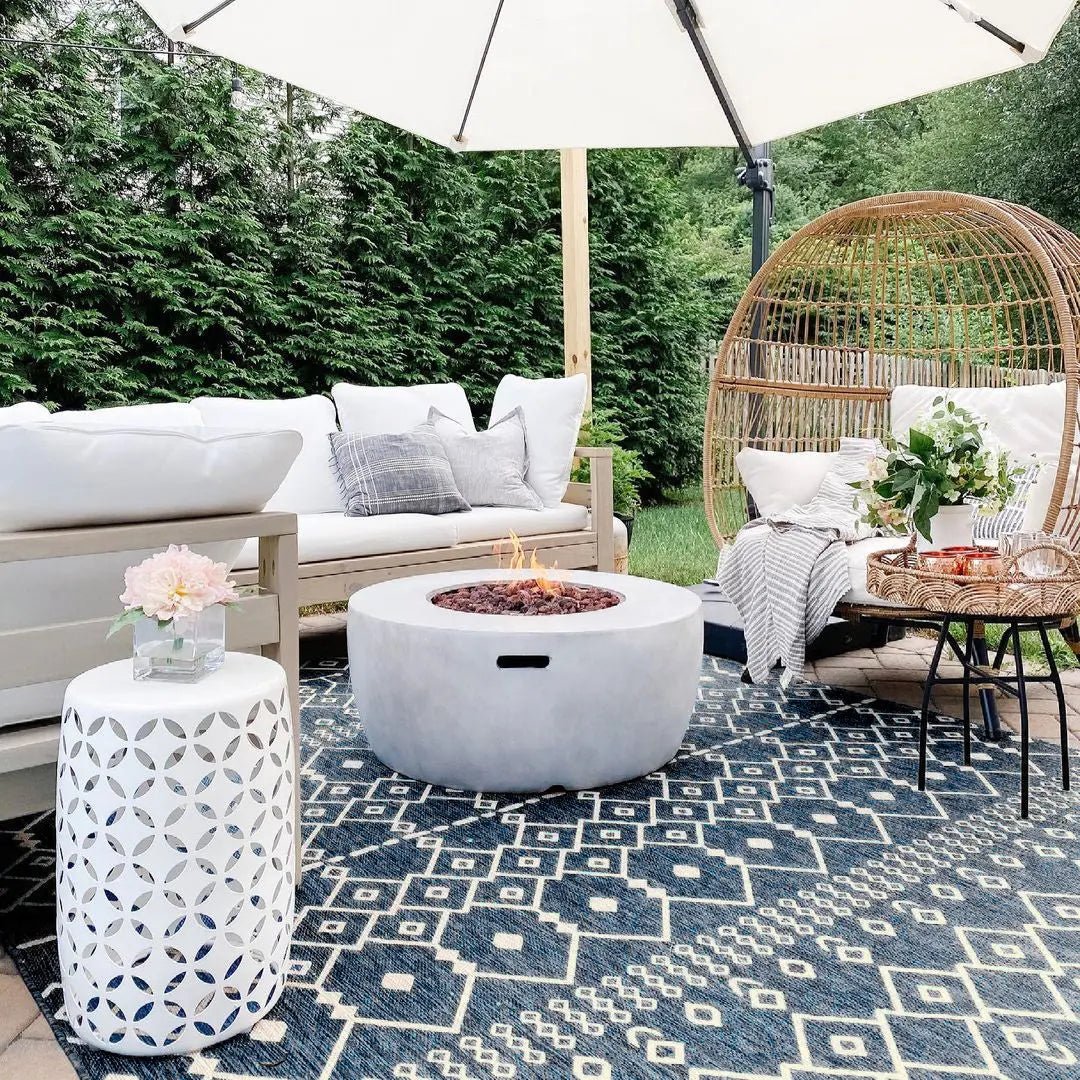 Nord Moroccan Tribal Indoor Outdoor Blue Flatweave Rug Well Woven - A blue outdoor rug in an outdoor patio setting with rattan furniture and greenery, showcasing its weather-resistant versatility.