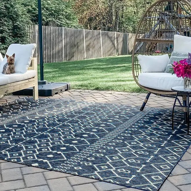 Nord Moroccan Tribal Indoor Outdoor Blue Flatweave Rug Well Woven - The blue rug in an outdoor space, partially shaded, showing its fade-resistant material.